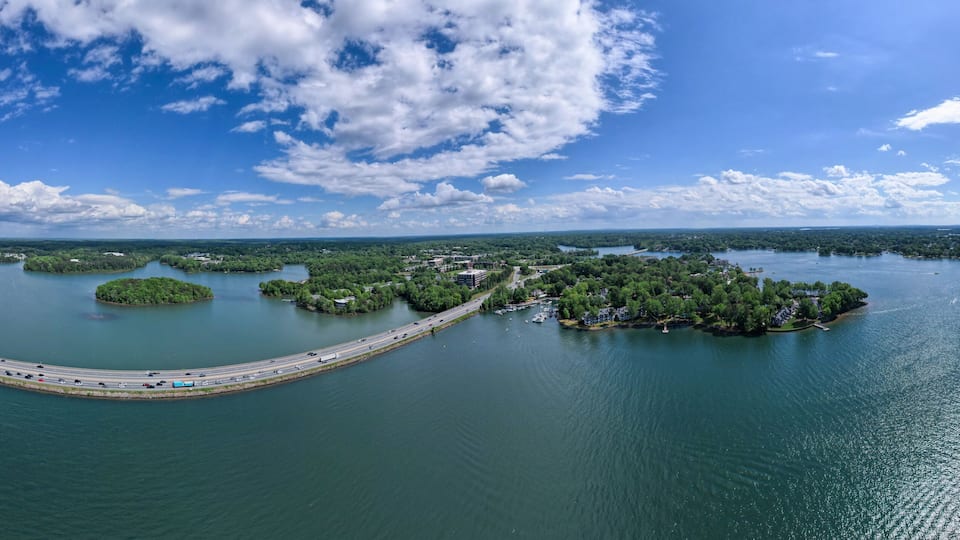 A coastal landscape with a bridge connecting islands, clear skies, and calm waters.