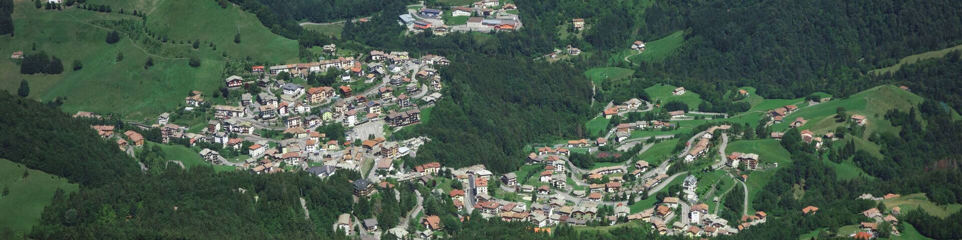 A mountainous village with scattered houses and dense forests.