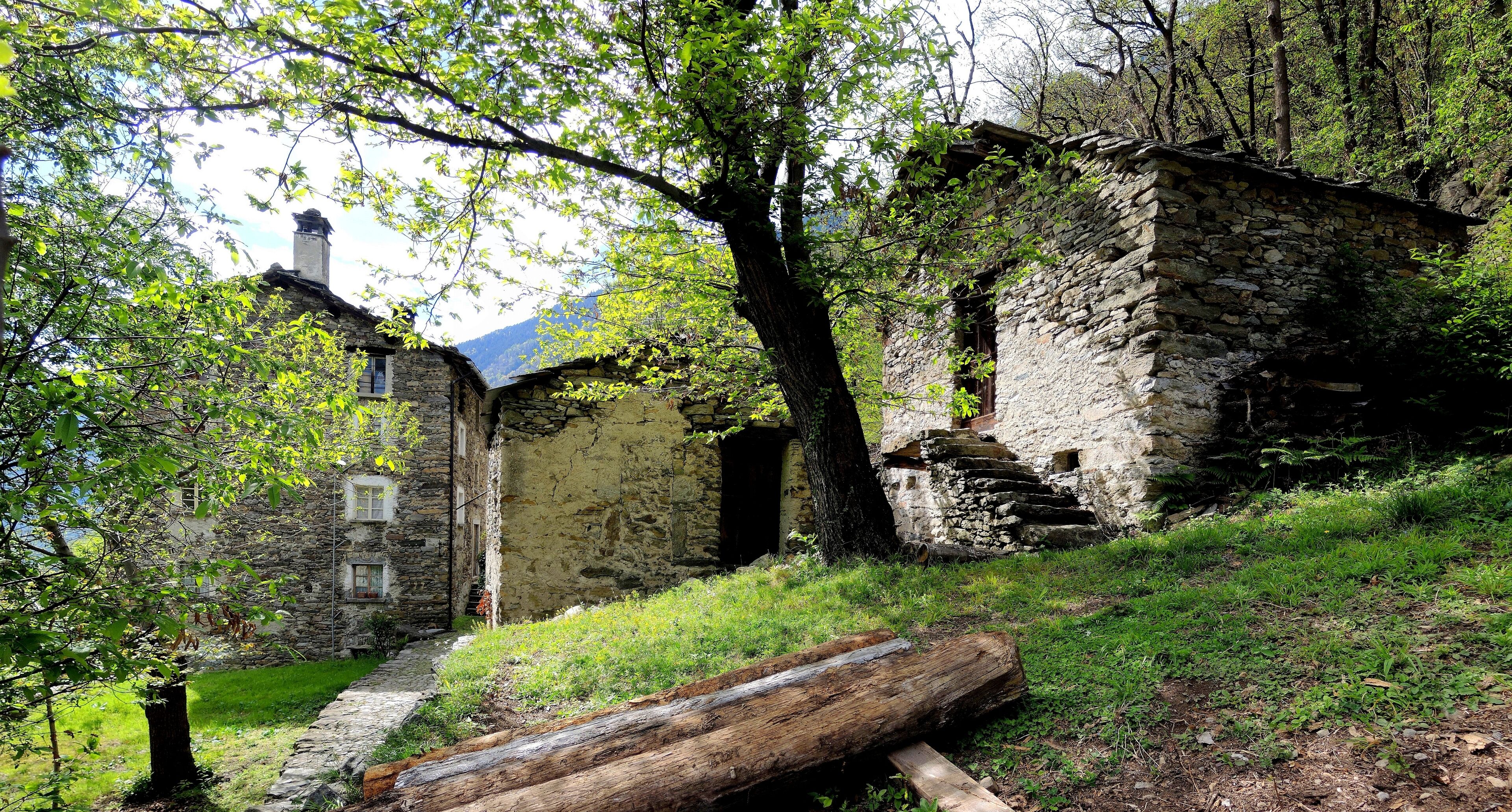 A stone building surrounded by trees and a grassy area.