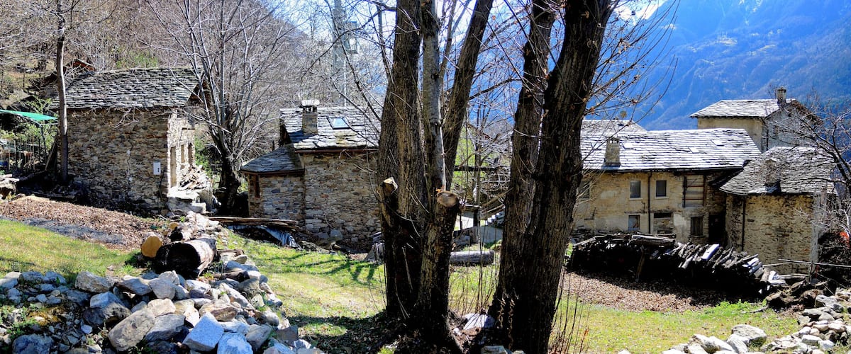 A mountainous village with stone houses, rocky terrain, and sparse vegetation.