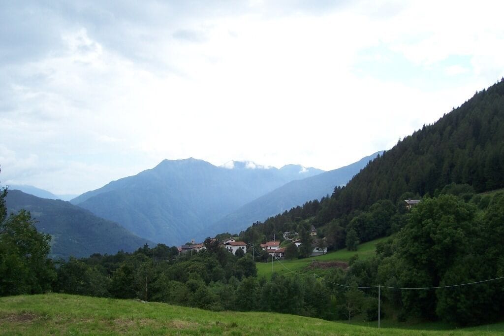 Un paisaje montañoso con un pueblo enclavado entre colinas.
