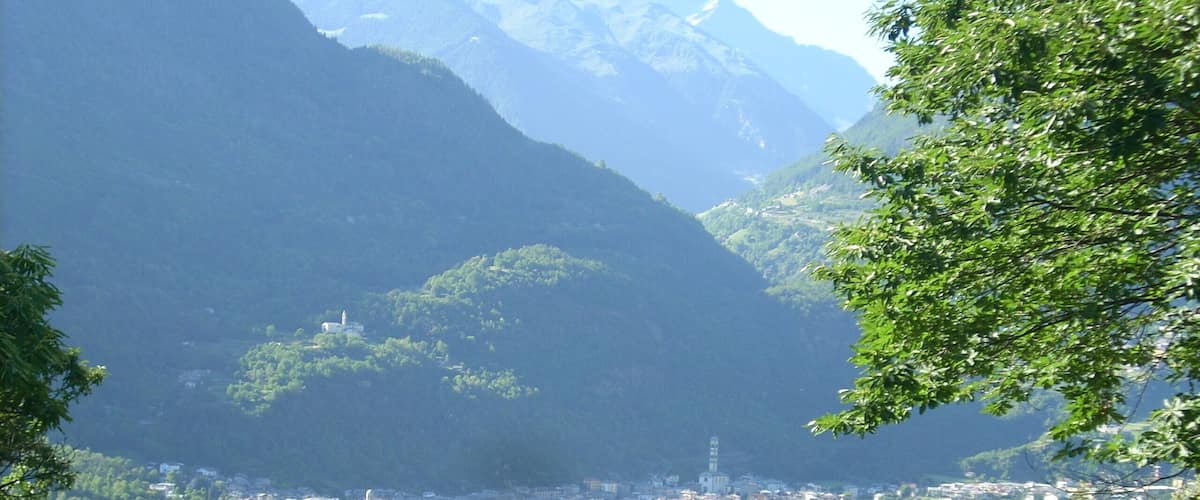 A town nestled in a valley with mountains in the background.