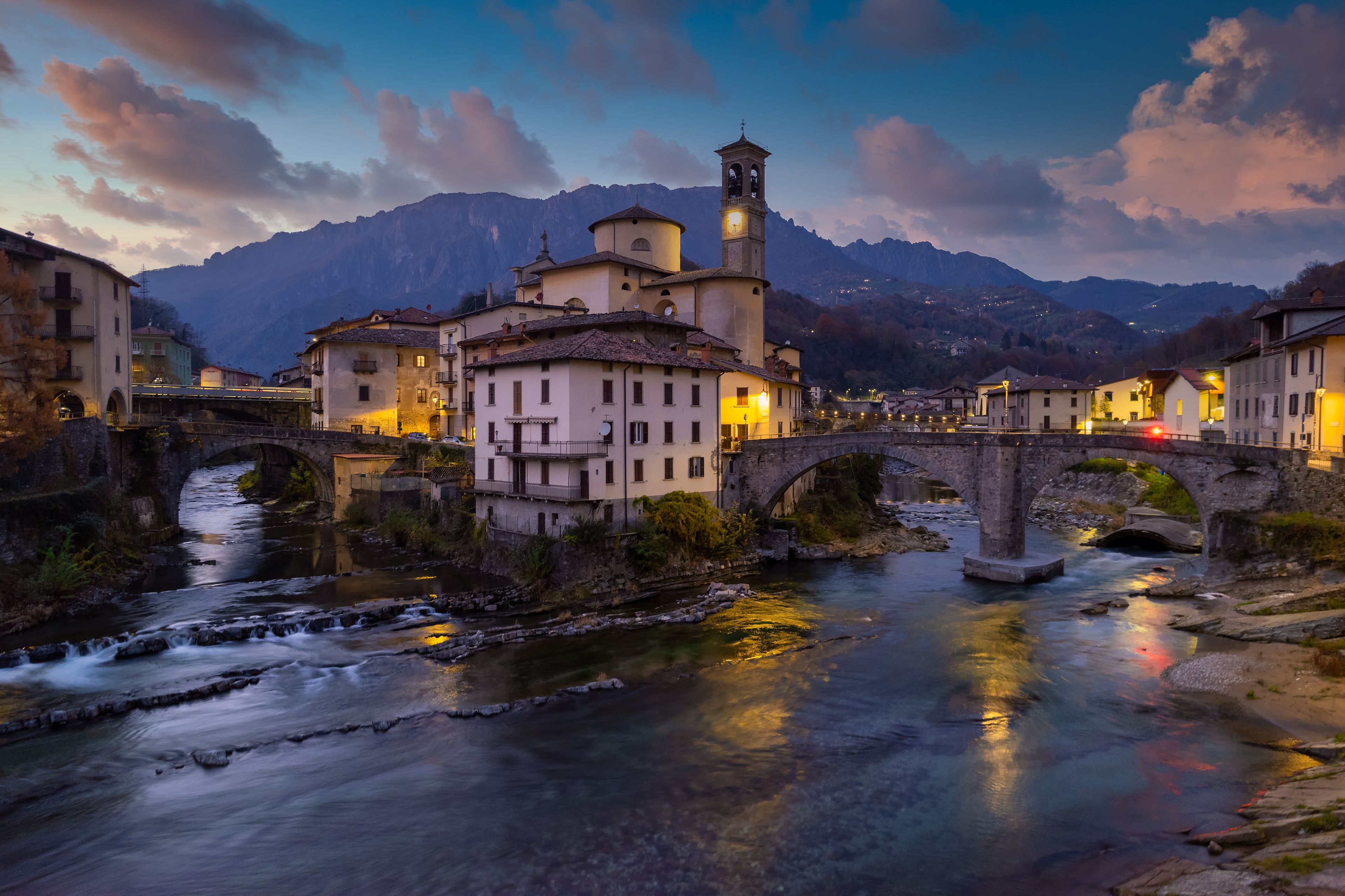 Aerial villagescape with mountain backdrop at night, San Giovanni Bianco, Val Brembana, Bergamo, Lombardy, Italy