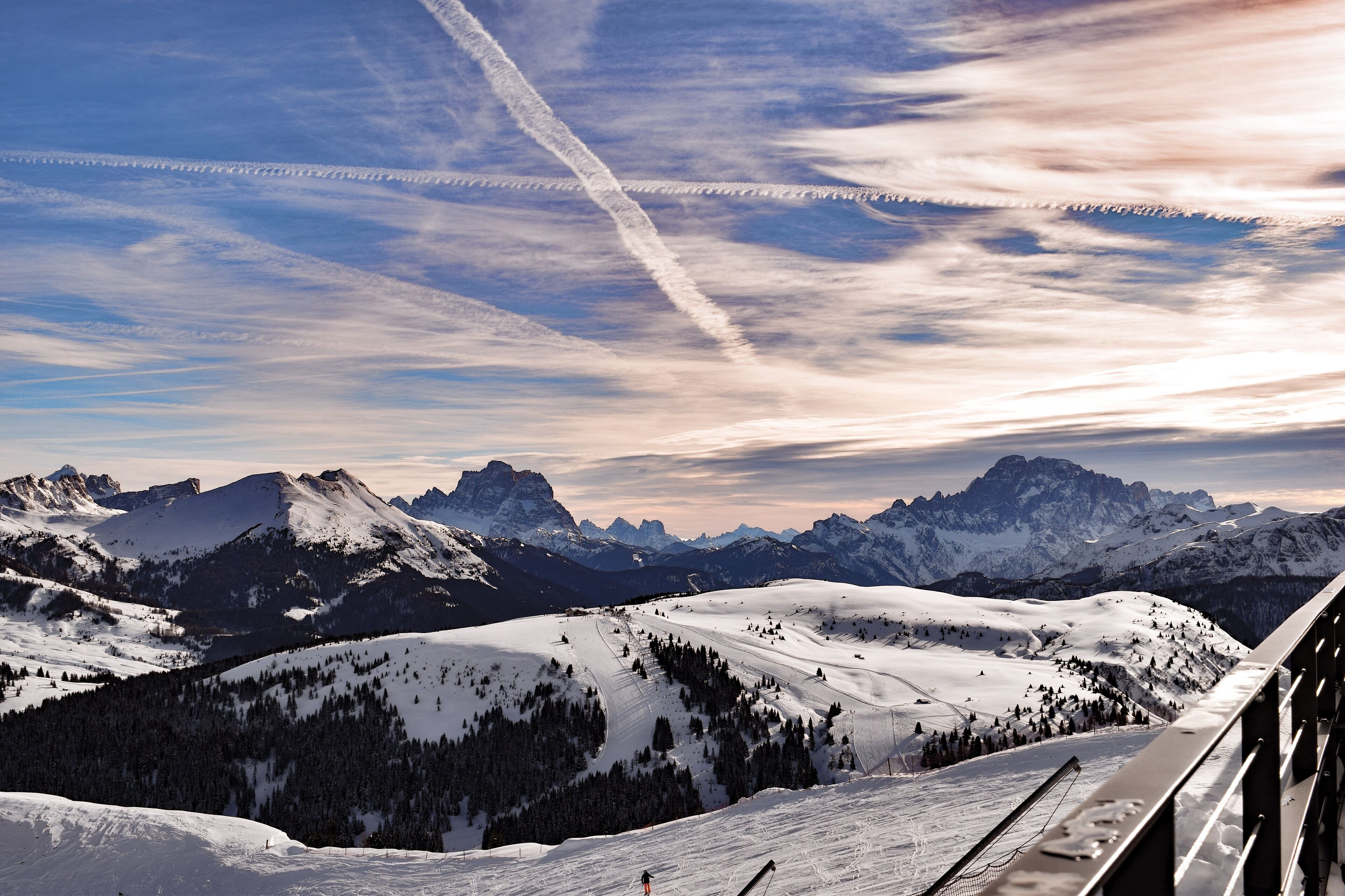 A snowy mountain landscape with ski slopes and ski lifts.