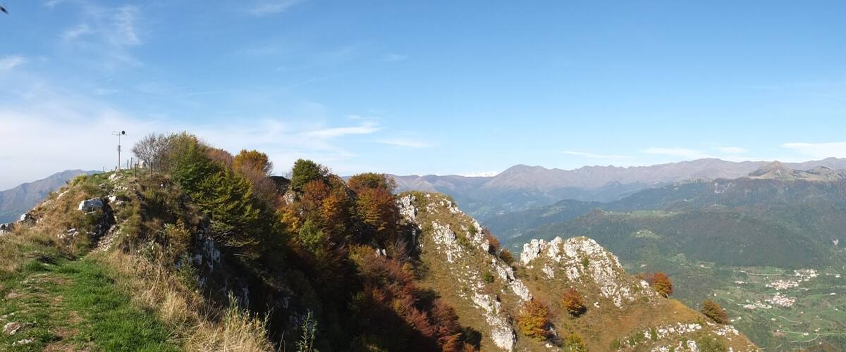 A mountainous landscape with rocky outcrops and a valley with scattered buildings.