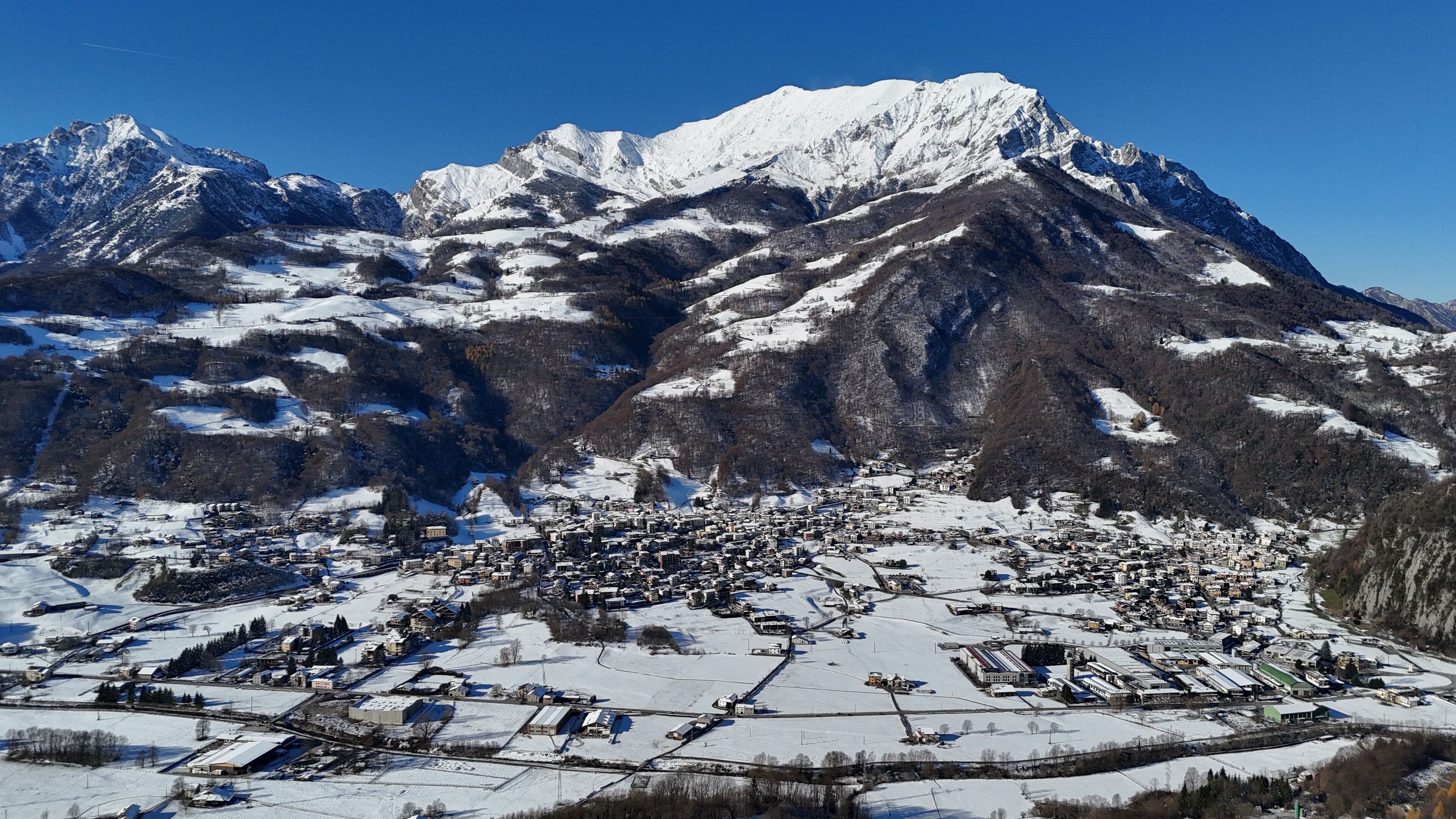 A snow-covered mountain range with a town nestled at its base.