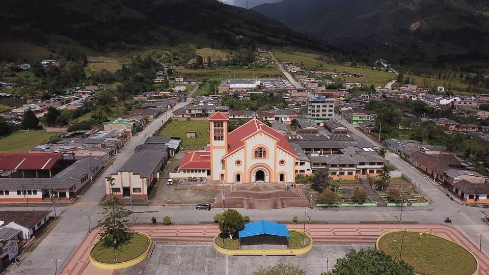 A town with a prominent church, a main road, and surrounding hills.