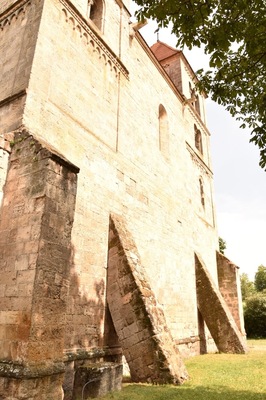 The #Romanesque church of Ócsa, that started out as a Catholic church, was a mosque during the Osman occupation and became a Calvinist church after that has no front gate. 
The space between the double stone walls was filled with rubble, water and cement. The church was supposed to be built further after the winter and there was a temporary closing wall in the front. The two huge counterforts were put there until they could go on.
But by next year the mixture filling up the space became so hard, that the temporary was couldn't be removed any more. No official entrance could be made