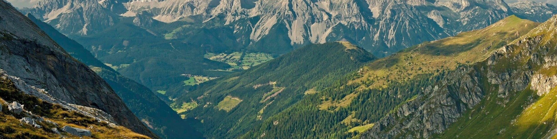 August 2011 
Hoher Dachstein massif, Austria
View of the massif of Hoher Dachstein from south through Preunegg pass on the way to Giglachsee lakes in Schladminger Tauern. 
Dachstein is a mighty karstic limestone range of ca. 20x30 km belonging to Northern Limestone Alps and has dozens of peaks higher than 2.500 metres. From south it has a prominence of more than 2.000 meters and descends steeply to valley of river Enns with city of Schladming. On its north side there are the most northern and most eastern glaciers of Alps. The top summit of Hoher Dachstein has altitude of 2.995 metres.