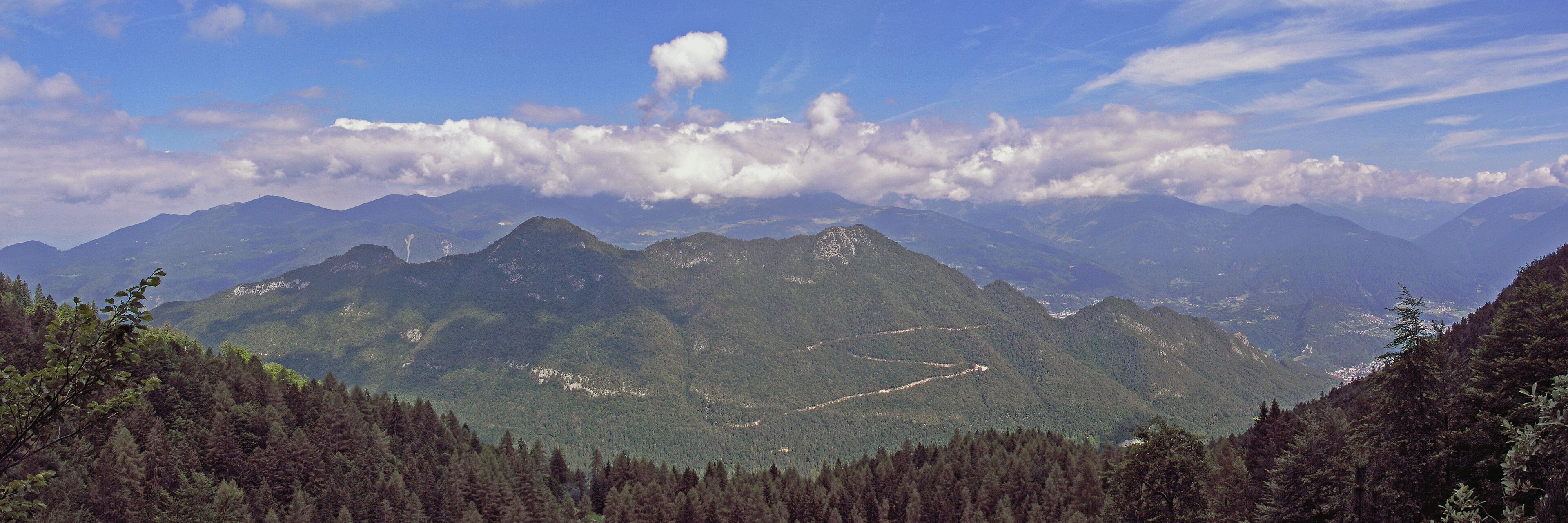 A mountain range with dense forests and a clear sky.