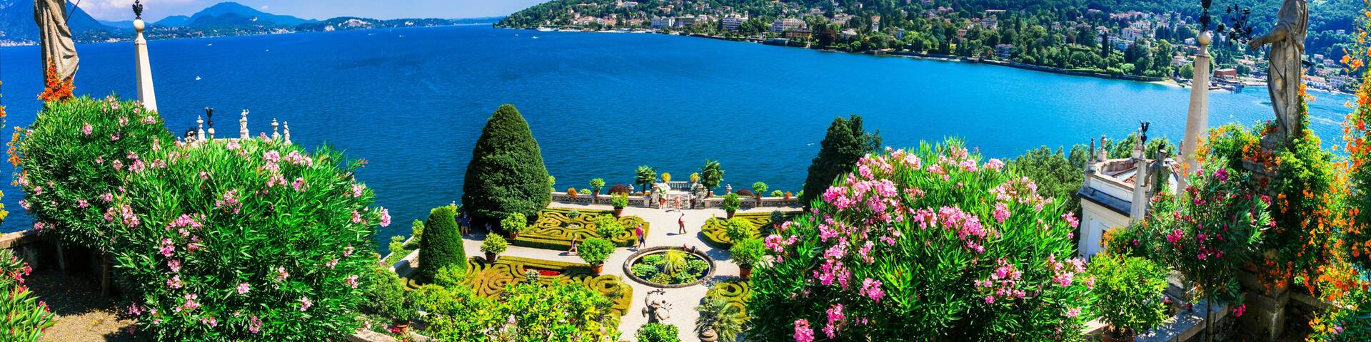 Ultra-wide panorama of Isola Madre botanical gardens and Lake Maggiore. Scenic aerial-style view of Borromean Islands and Alpine lake landscape, Italy.