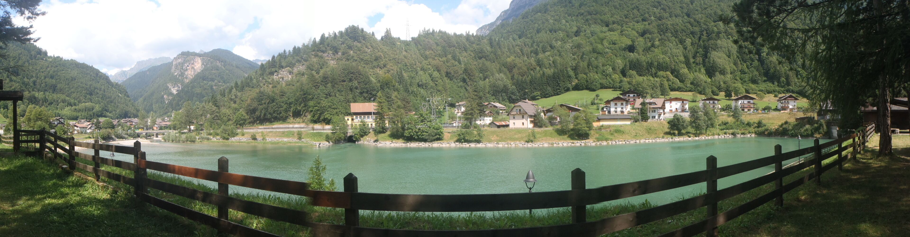 A lake surrounded by mountains and houses.