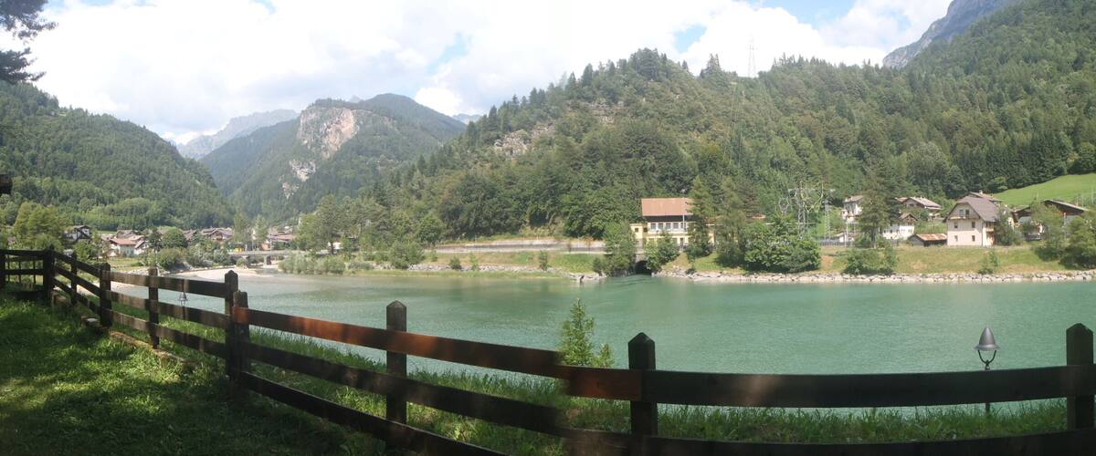 A lake surrounded by mountains and houses.