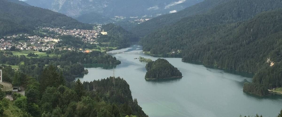 A mountainous landscape with a river, a town, and a lake.