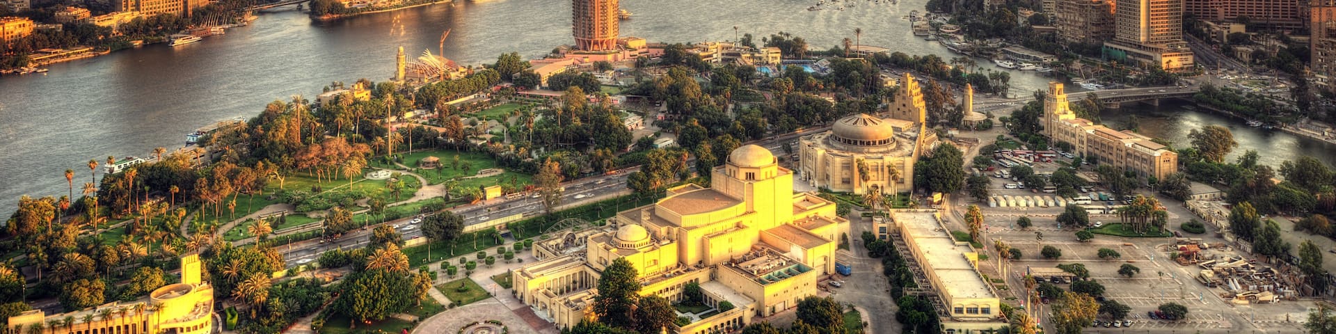 A cityscape with a river, high-rise buildings, and a large historical building with a dome.