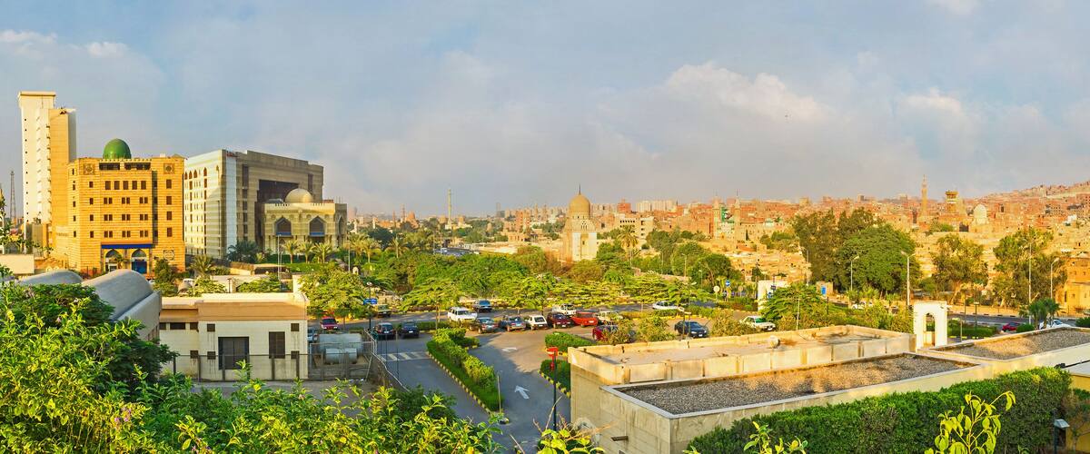A cityscape with a prominent mosque, a mosque dome, and a minaret.