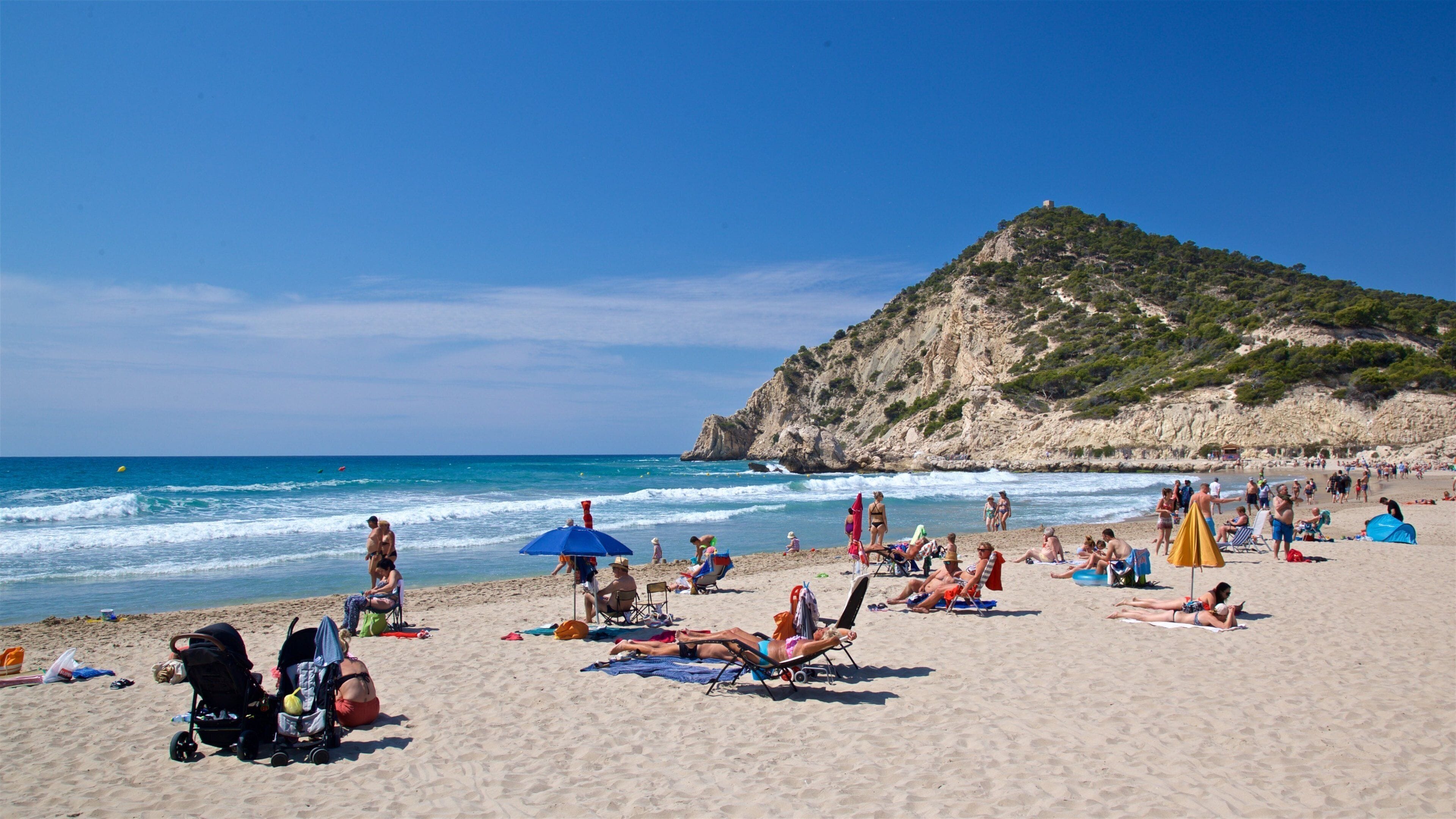 La Cala Beach showing a sandy beach and general coastal views as well as a small group of people