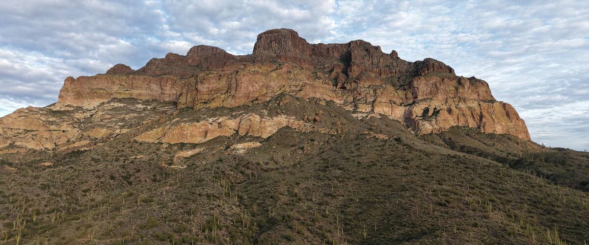 A rugged mountain range with prominent peaks and sparse vegetation.