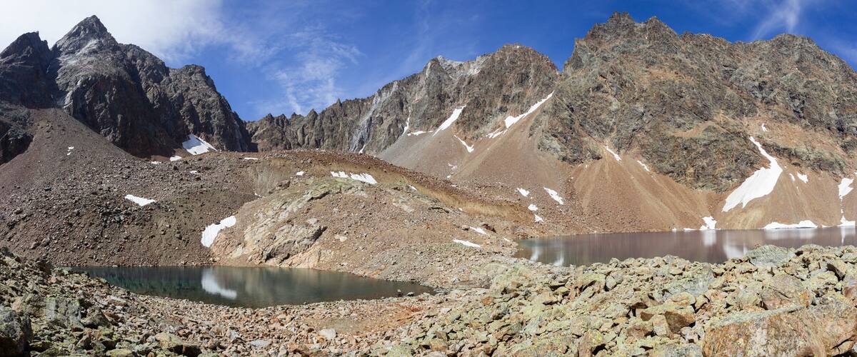 A mountain landscape with rocky terrain and a small lake.