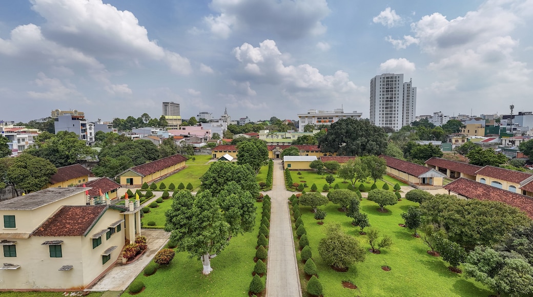 Aerial view of the Dak Lak Museum with its red-tiled roofs contrasting against the vibrant green lawns and clear blue sky, Buon Ma Thuot, Dak Lak, Vietnam.
