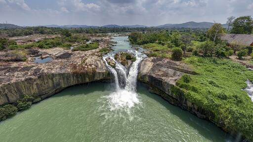 Aerial view of the dramatic cascade of Dray Nur Waterfall plunging into the river amidst lush greenery, Buon Ma Thuot, Dak Lak, Vietnam.