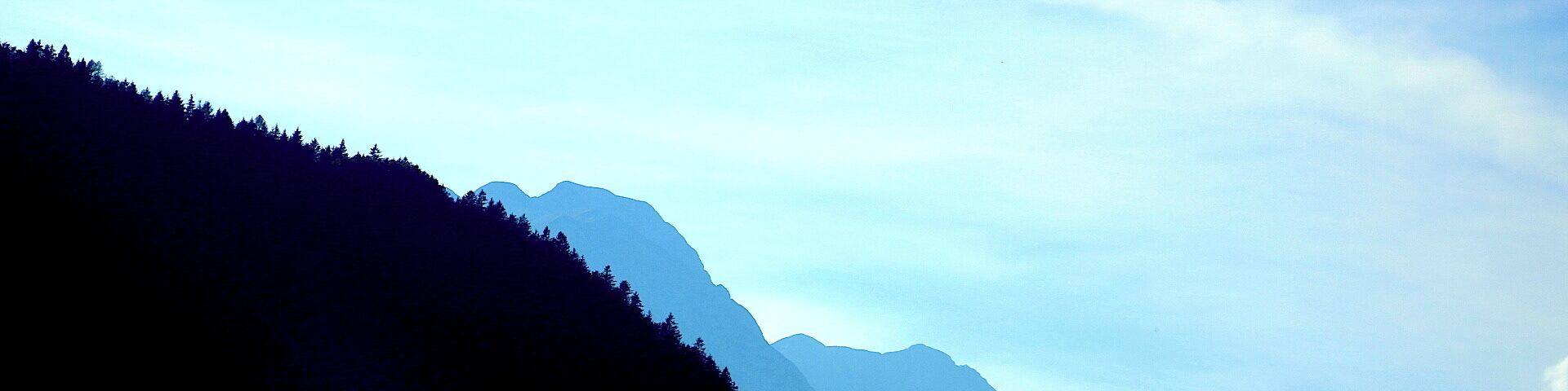 A mountain range with a forested slope.
