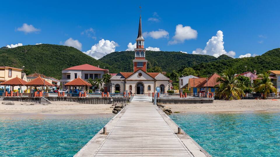 A coastal town with a church, pier, and beach.