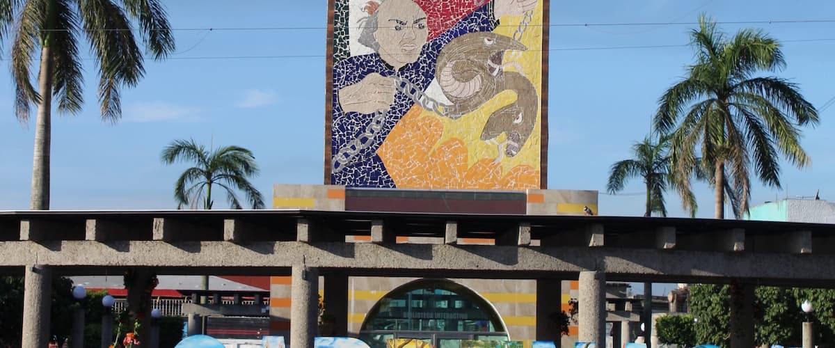 A tall clock tower with a mosaic mural and the word 'CARIÑAS' below it.