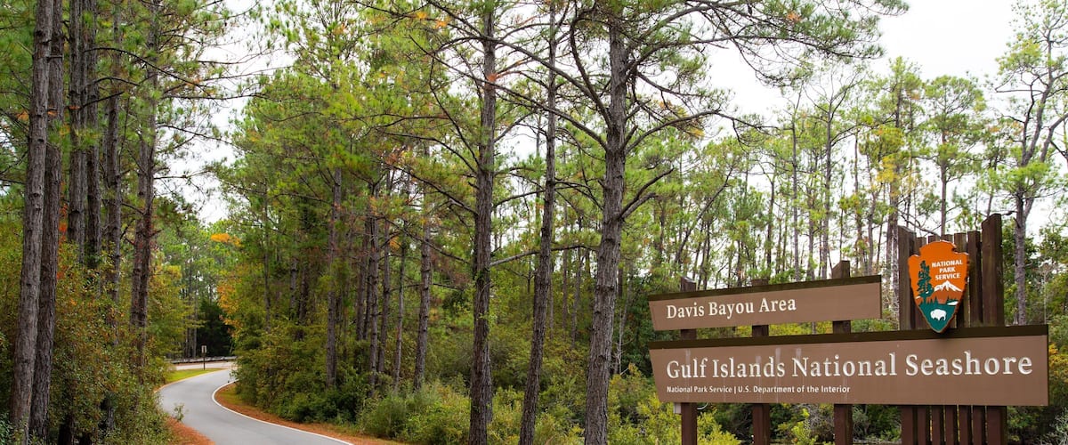 Gulf Islands National Seashore Davis Bayou featuring signage and a pond