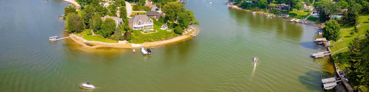 Aerial View of North Shore on Mona Lake, Norton Shores, Michigan – Scenic Peninsula with Homes and Forest” Stunning aerial drone view of the North Shore neighborhood along Mona Lake in Norton Shores,