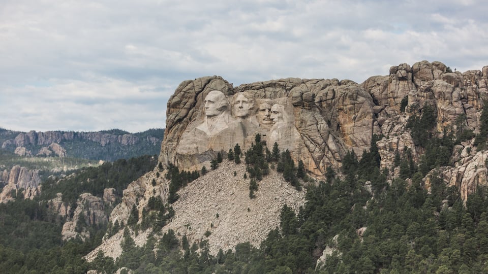 Mount Rushmore with four presidential faces carved into the rock.