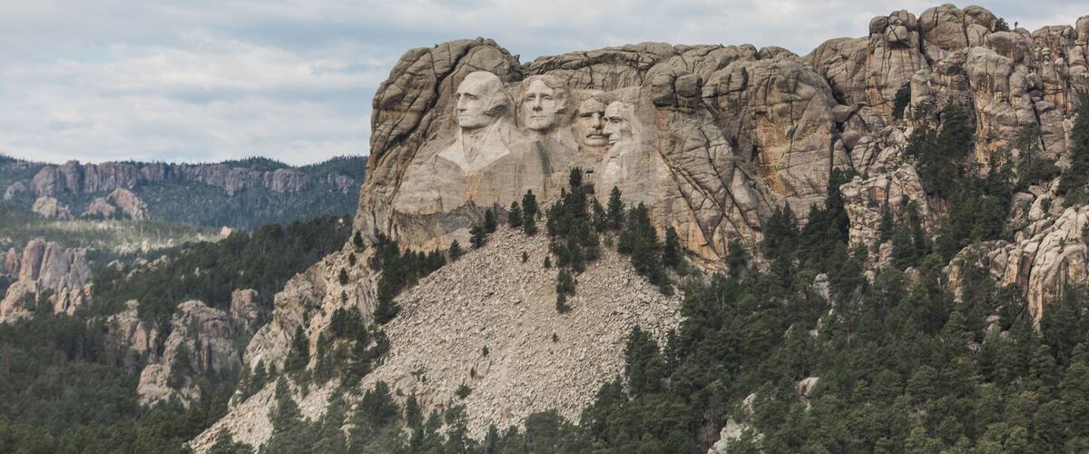 Mount Rushmore with four presidential faces carved into the rock.
