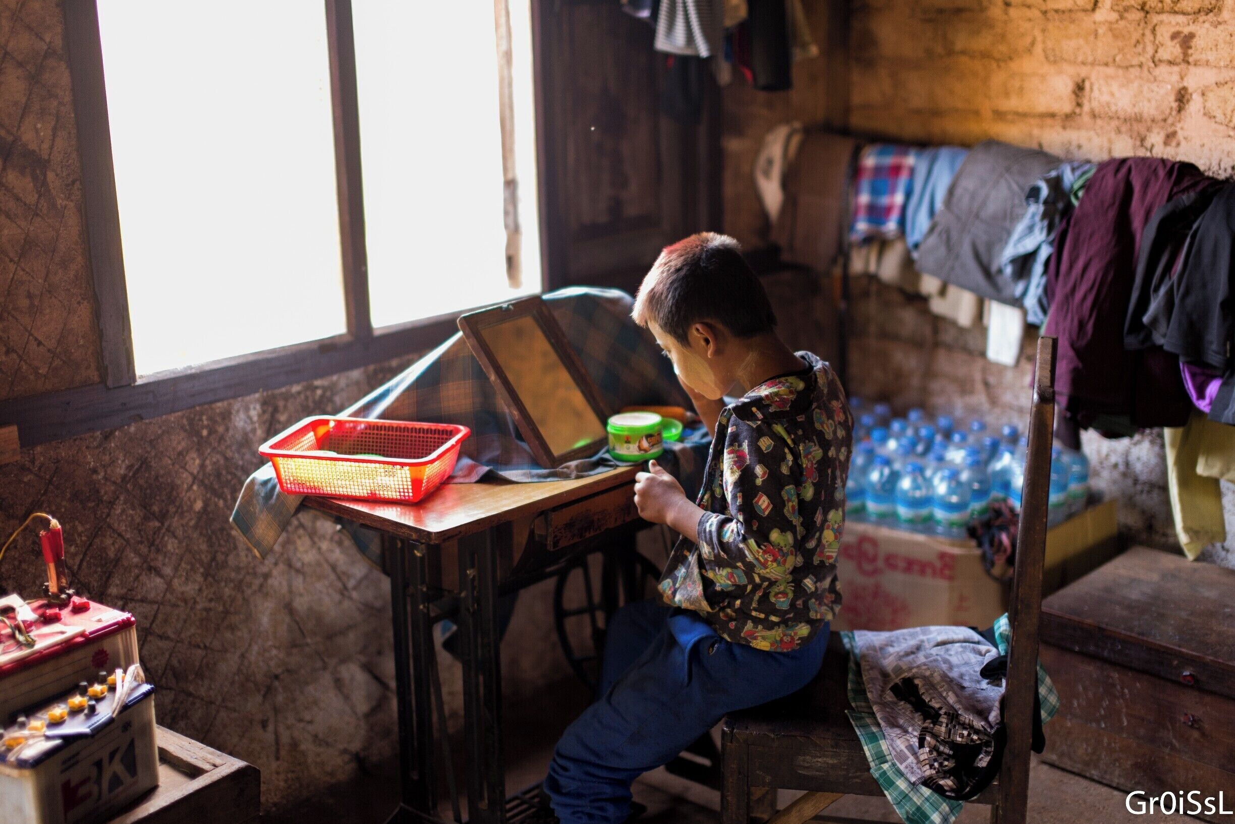In the morning of our second day trekking throughout the mountains in different villages outside Hsipaw Myanmar, this boy who lives at the home stay puts on his traditional face mask called, Thanaka. Thanaka is a yellowish-white paste made from ground bark.
