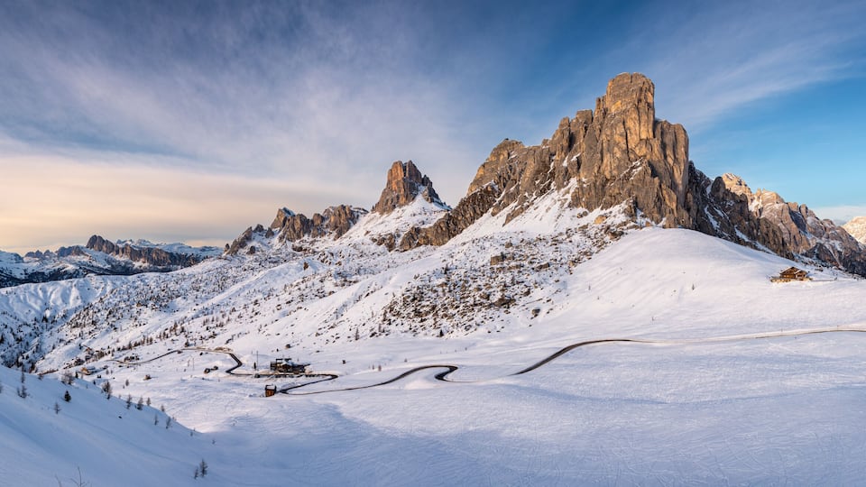 A snow-covered mountain peak with a ski resort and a clear sky.