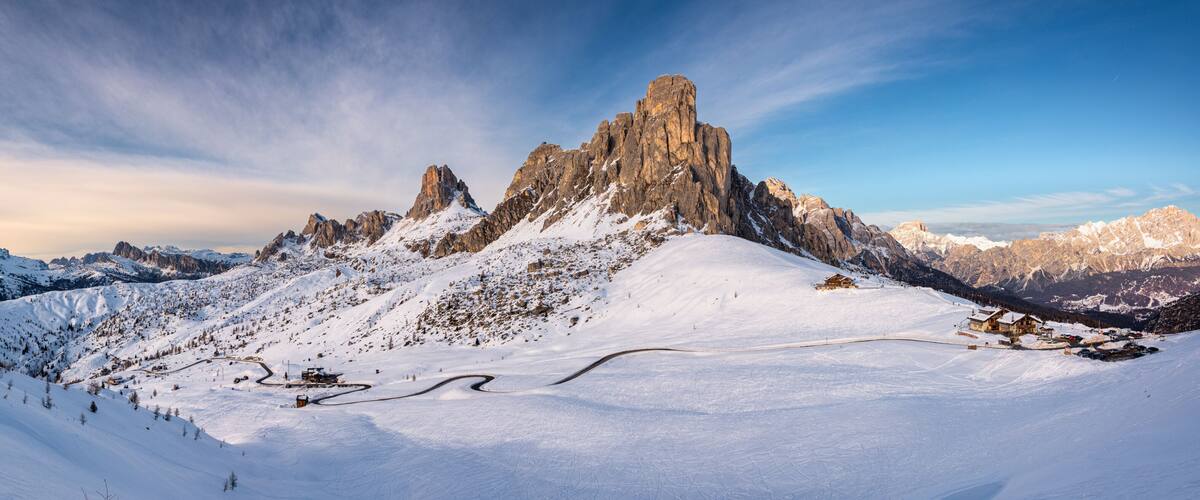 A snow-covered mountain peak with a ski resort and a clear sky.