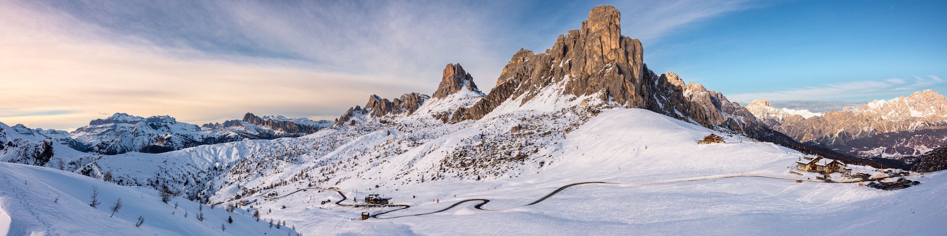 A snow-covered mountain peak with a ski resort and a clear sky.