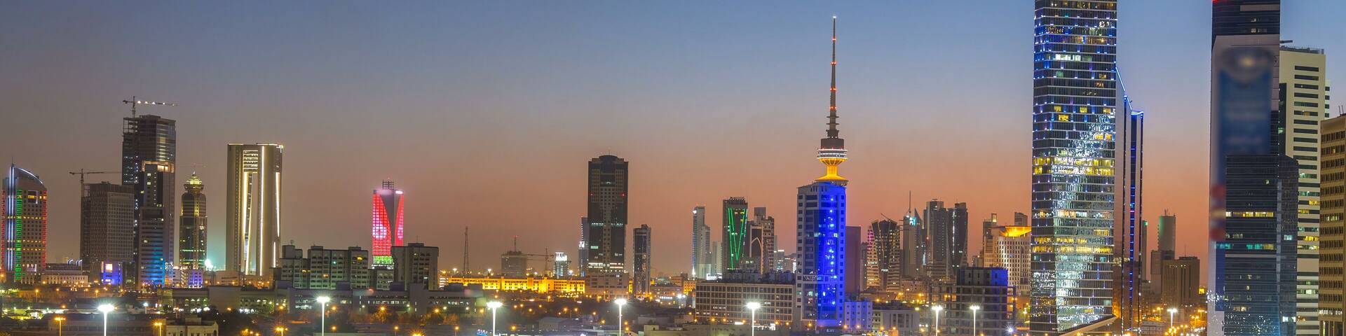 Skyline with Skyscrapers day to night timelapse in Kuwait City downtown illuminated at dusk. Kuwait City, Middle East