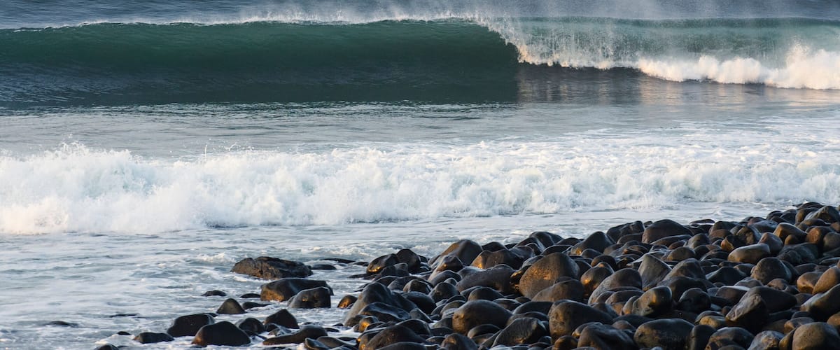 A rocky shoreline with waves crashing onto the rocks.