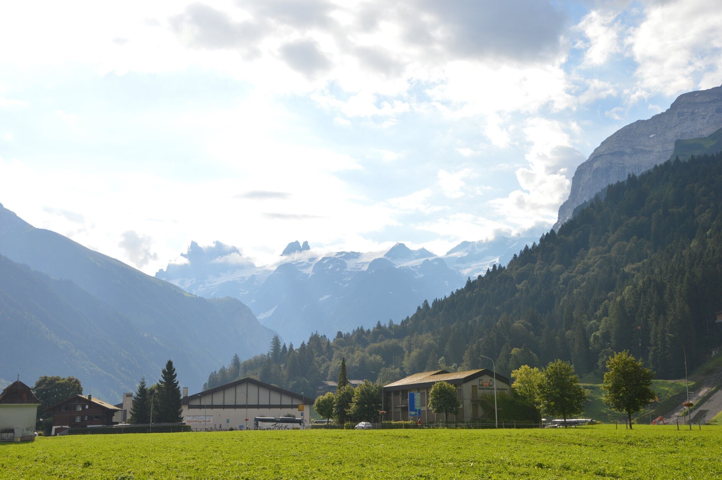 A mountainous landscape with a village, green fields, and buildings.