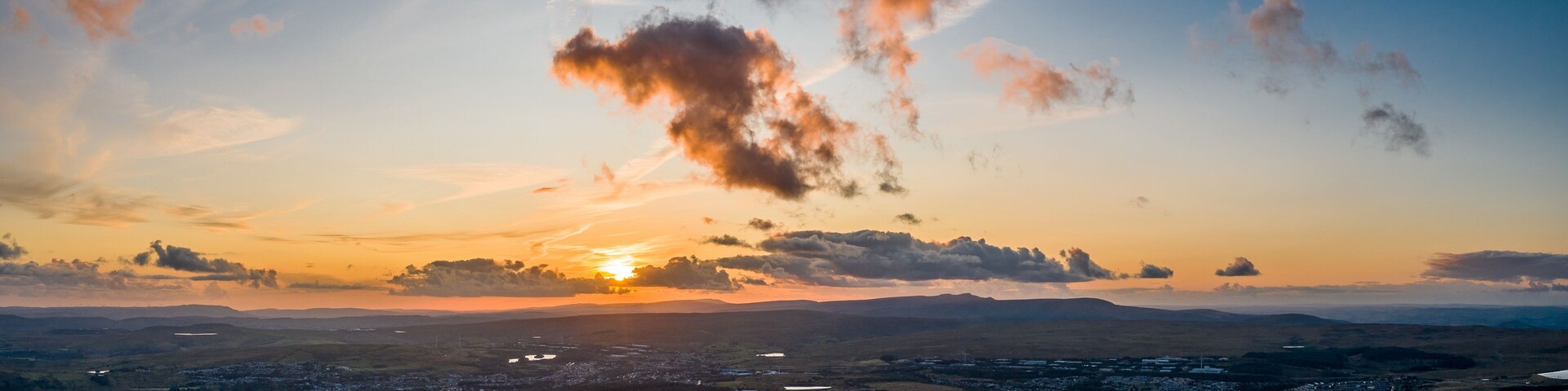 Un atardecer sobre un paisaje urbano con nubes dispersas.