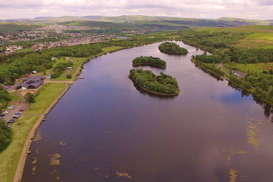 A river with three small islands surrounded by greenery.