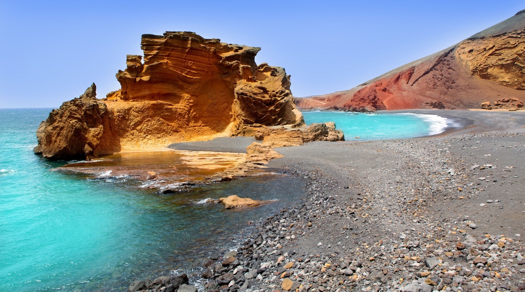 Une cĂŽte rocheuse bordĂ©e dâeaux turquoise cristallines et surmontĂ©e dâune formation rocheuse imposante.