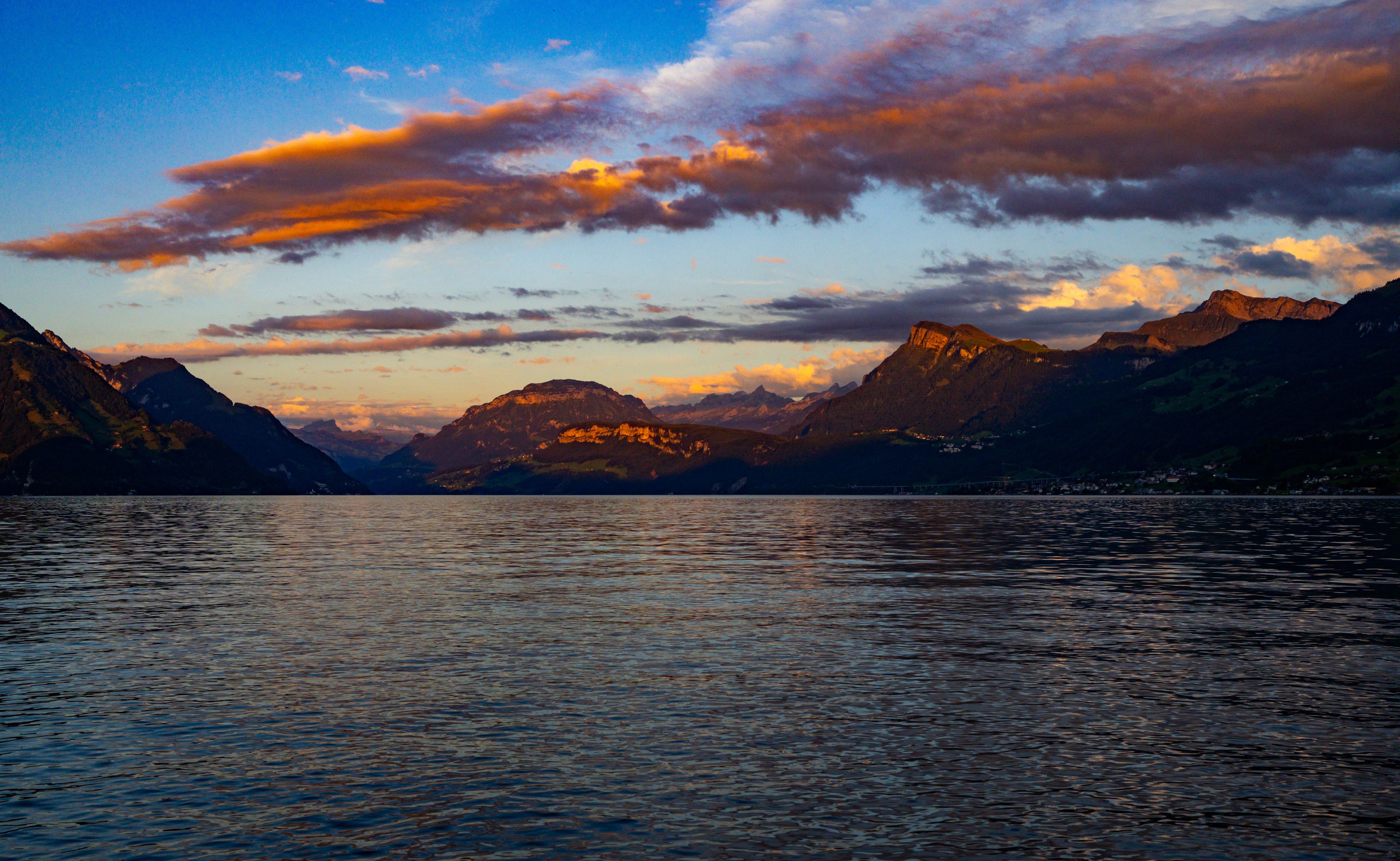 Mountain cloudscape across Lake Lucerne and Alps. Mountain lake view in Canton Schwyz. Summer landscape with mountain clouds near Brunnen. Switzerland tourism destination with mountain panorama.