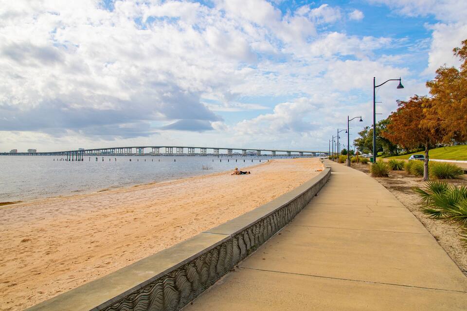 A beach with a pier in the background.