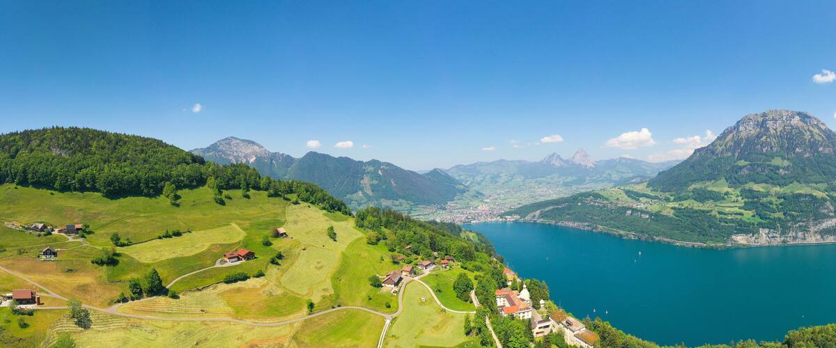 A mountainous landscape with a lake and scattered houses.