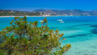 A coastal landscape with clear turquoise waters, rocky shorelines, and boats.