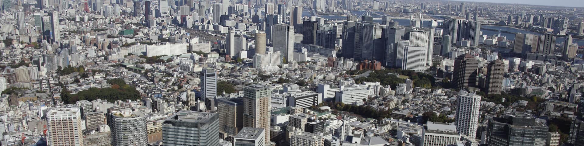 A densely packed urban landscape with numerous high-rise buildings and a prominent tower in the distance.
