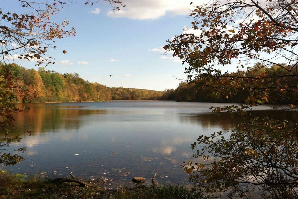 A calm lake surrounded by autumn foliage.