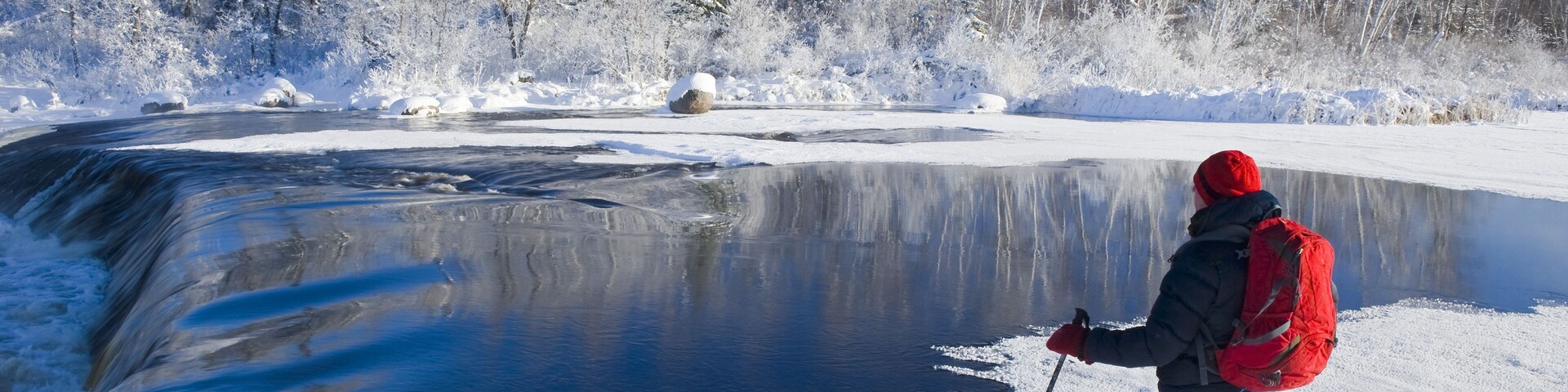 Snowshoeing in winter along Whiteshell River at Rainbow Falls, Whiteshell Provincial Park; Manitoba, Canada