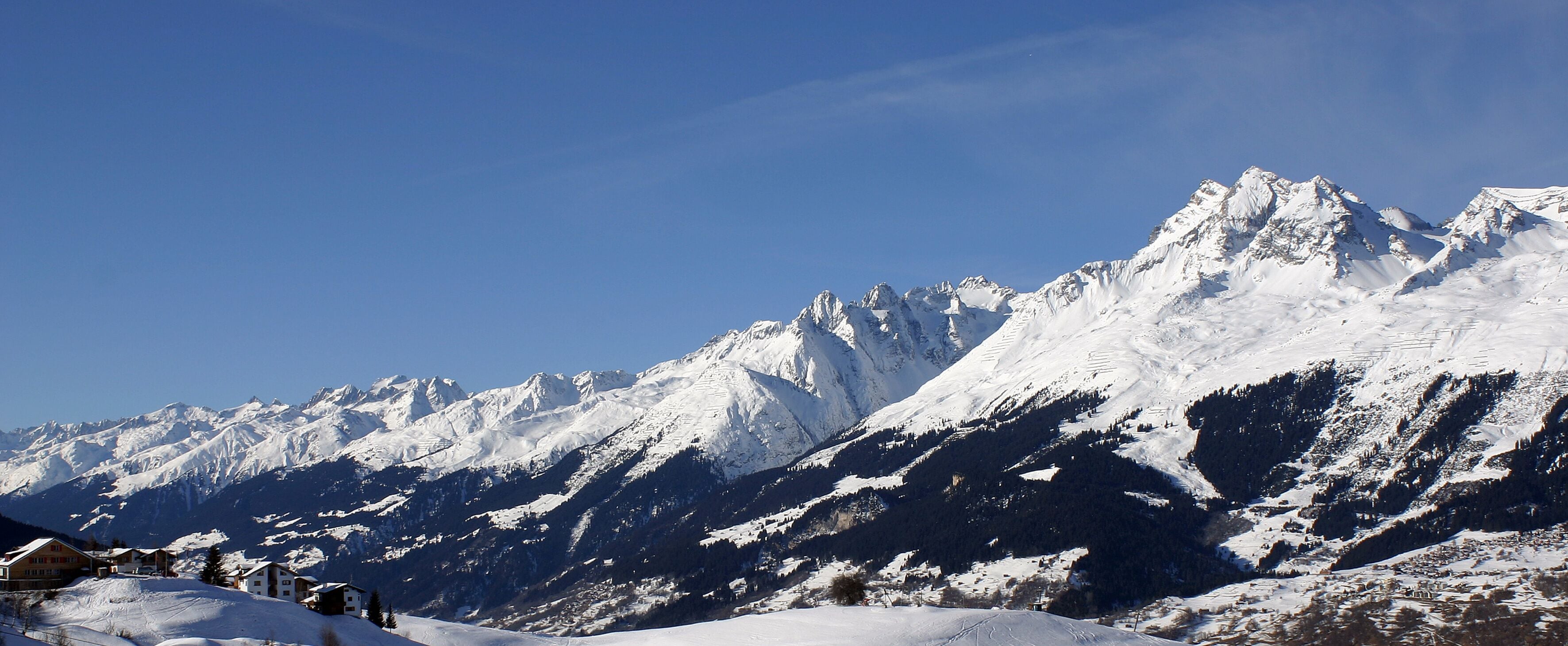 A snow-covered mountain range with clear blue skies.
